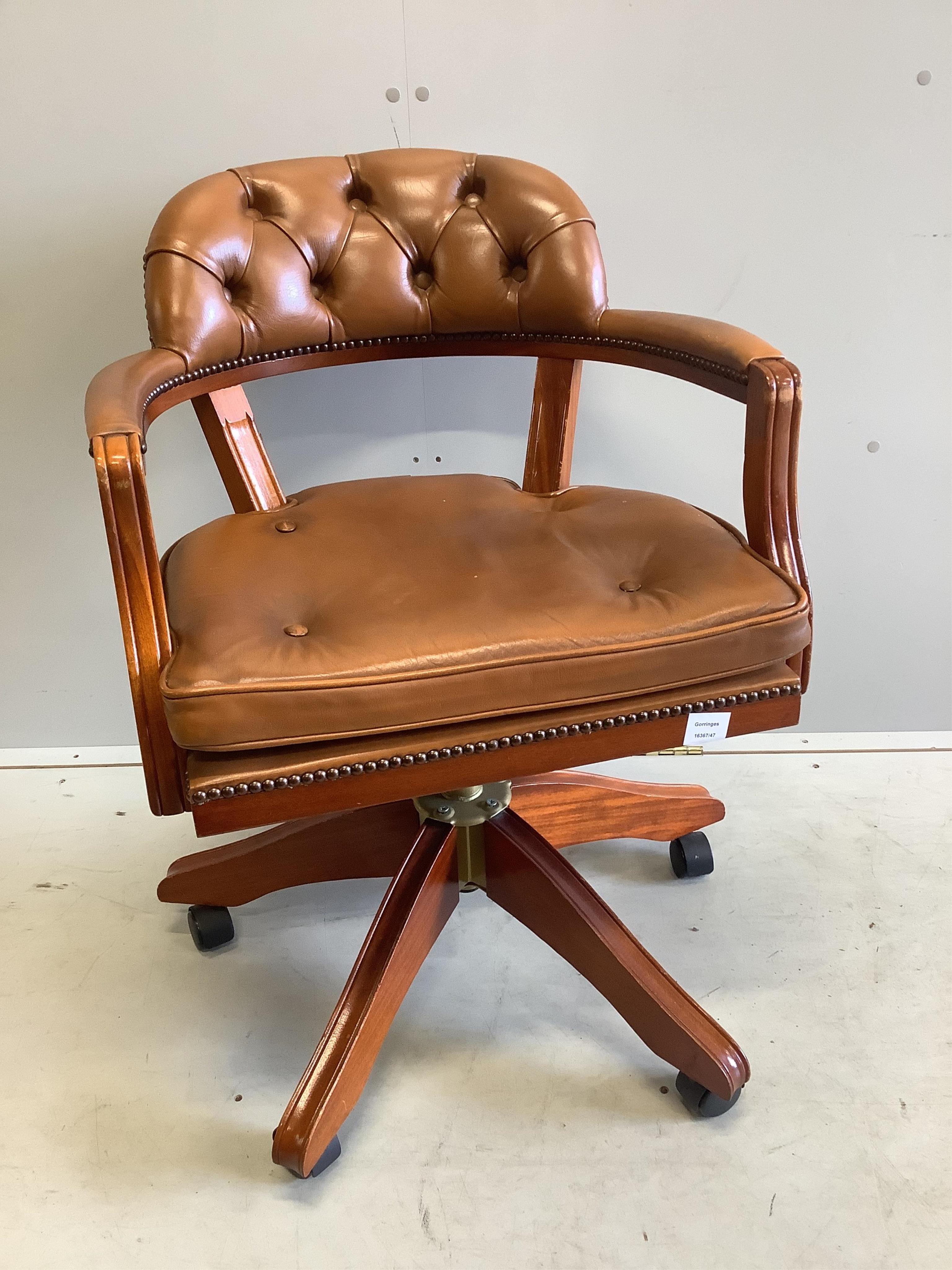 A modern mahogany and tan leather swivel desk chair, width 60cm, depth 50cm, height 86cm. Condition - good